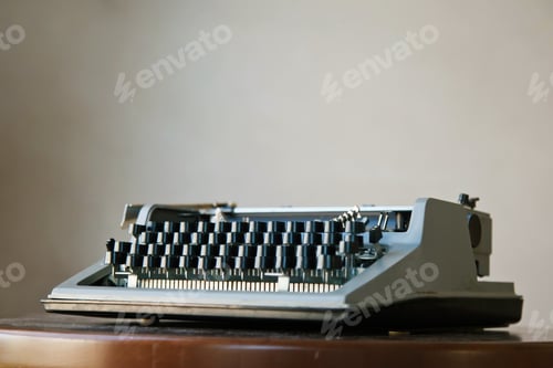 Preview: Old classic retro typewriter on dusty Desk against beige wall background