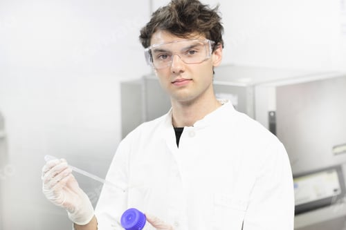 Preview: Scientist holding dropper in lab