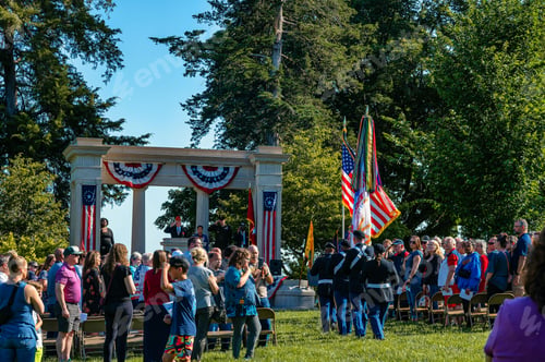 Preview: Patriotic outdoor ceremony with people standing and military personnel holding flags