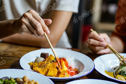 Preview: Young Asian couple traveler tourists eating Thai street food together in Laplae District market.