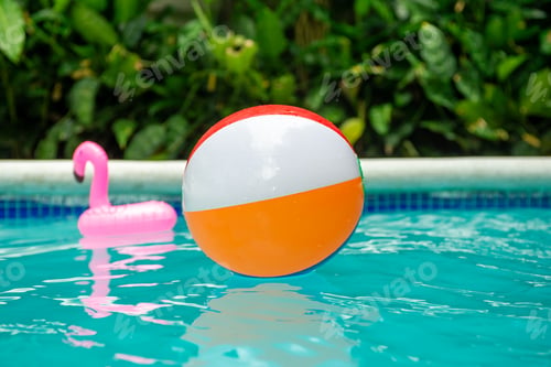 Preview: Bright Colorful Beach Ball and Inflatable Flamingo in a Swimming Pool