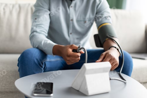 Preview: Unrecognizable African Man Measuring Arterial Pressure Having Hypertension At Home