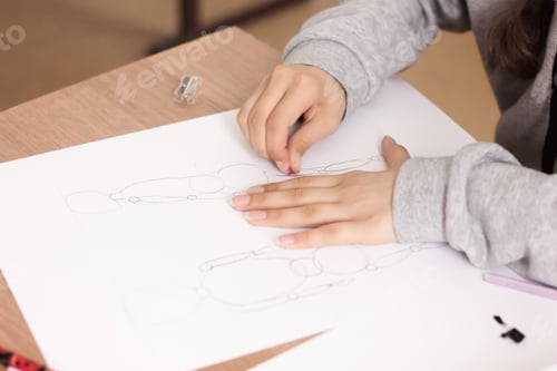 Preview: cropped view of teenager girl drawing and erasing sketch on a paper
