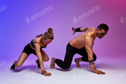 Preview: Beautiful young acrobats or gymnasts with colorful face painting on pink blue gradient background