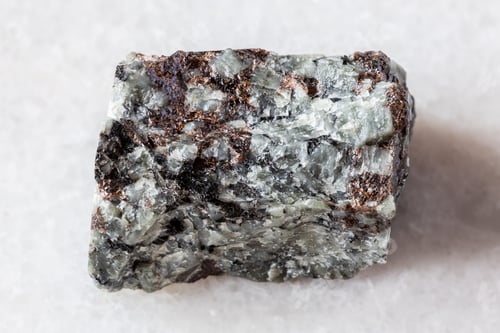 Preview: raw khibinite with eudialyte rock on white marble