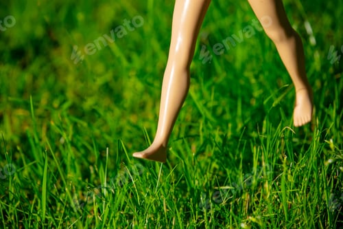 Preview: Doll run over green grass in a garden