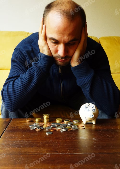 Preview: Worried male looking at the coins on the table