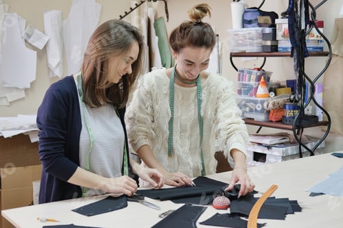 Preview: Seamstresses Measure The Fabric For Sewing A Dress In The Atelier. Two Female Tailor Working In In