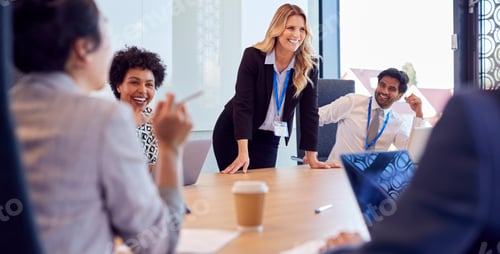 Preview: Businesswoman Leading Multi-Cultural Business Team Meeting And Collaborating Around Table In Office