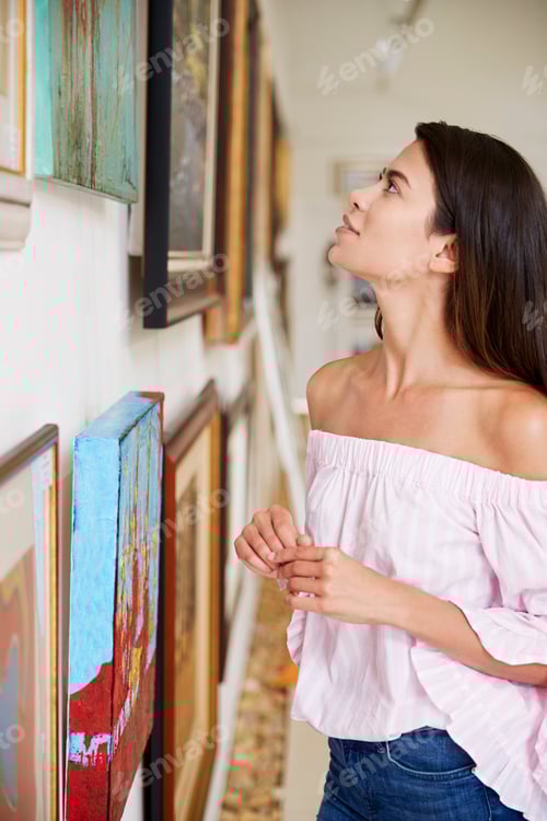 Preview: Woman Looking At Paintings In Art Gallery
