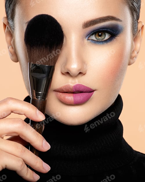Preview: Portrait of a girl with cosmetic brush at face.