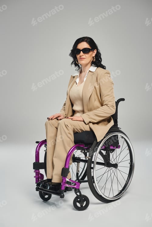 Preview: good looking woman with mobility disability in wheelchair sitting in wheelchair wearing sunglasses