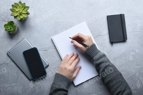 Preview: Person writing in a notebook