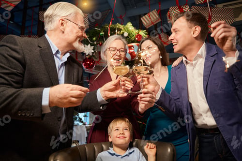 Preview: Family having fun with sparklers holding glasses of champagne celebrate new year