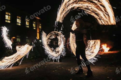 Preview: Fire dancers swing, spinning fire and man juggling with bright sparks in the night