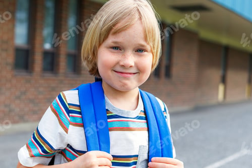 Preview: Happy smiling schoolboy walking to school, carrying backpack. Back to school concept.