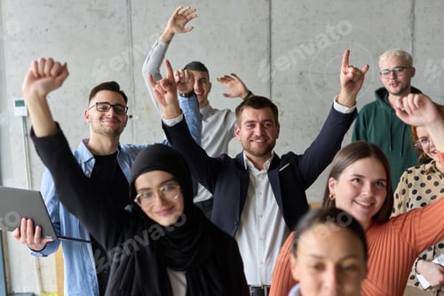 Preview: A diverse team of business professionals ecstatically celebrating their success in a modern office