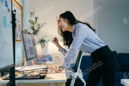 Preview: Happy businesswoman celebrates a big win in the office, embodying success and excitement. She works