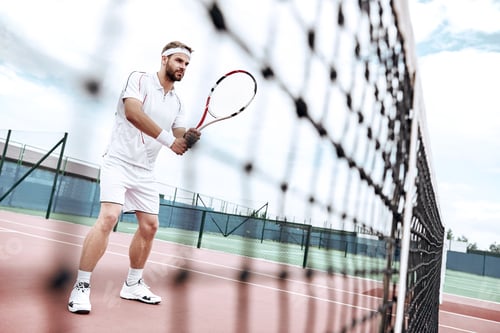Preview: Tennis player is getting ready for the game. Handsome tennis player is standing on the court, near