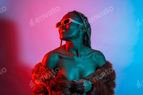 Preview: Attractive black ethnic woman with braids with red blue led lights, trap dancer wearing sunglasses