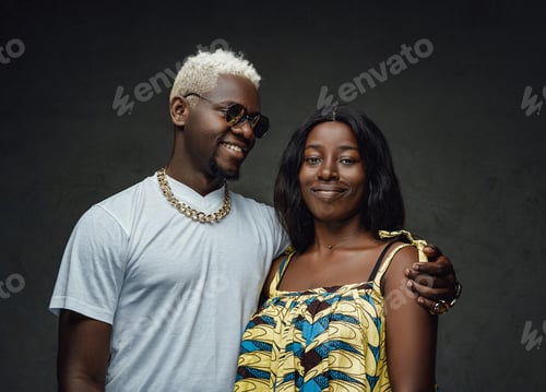 Preview: Happy couple of african descent posing against dark background