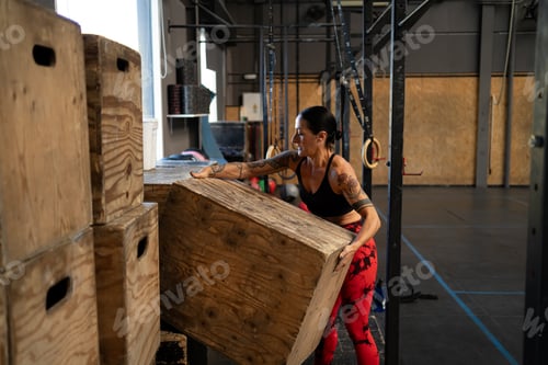 Preview: Woman organizing equipment alone in a cross training gym