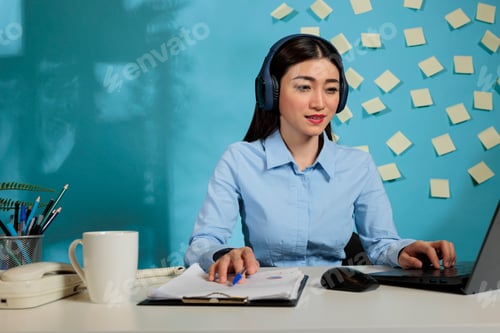Preview: Woman Working at Desk with Laptop and Notes