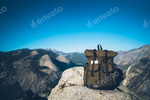Preview: Touristic backpack on top of mountain in sunlight