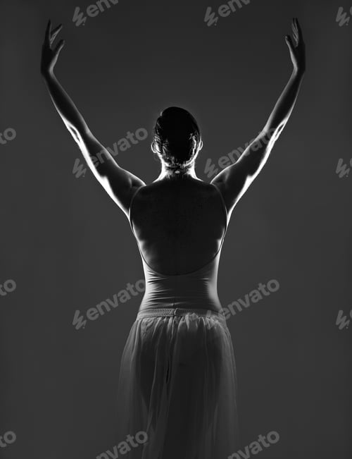 Preview: Grace in every curve. Silhouette of a young ballerina dancing against a dark background.