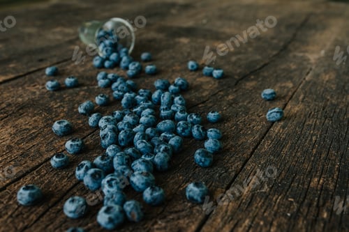 Preview: blueberries filled in a transparent glass and scattered