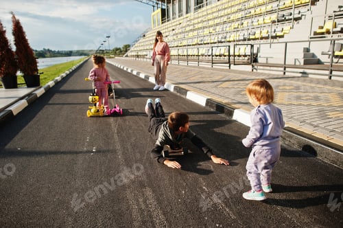 Preview: Young stylish mother with four kids outdoor