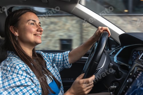 Preview: Joyful female driver in modern car. Smiling woman behind the wheel
