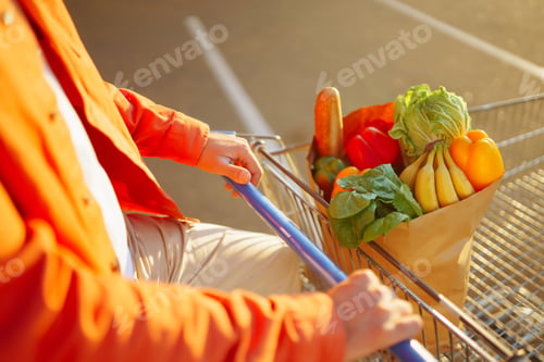 Preview: Young man with shopping bag full of vegetables near the car. Healthy lifestyle.