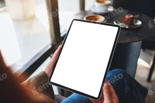 Preview: Mockup image of a woman holding black tablet pc with blank white screen in cafe
