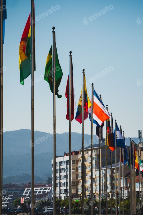 Preview: Vertical shot of the different county flags against the background of the buildings