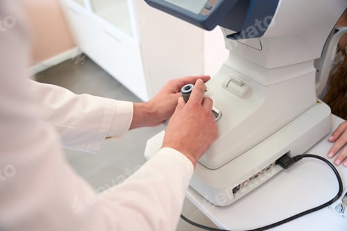 Preview: Unrecognized ophthalmologist is operating slit lamp in the clinic