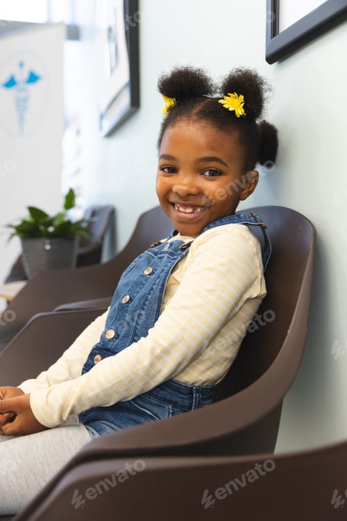 Preview: Portrait of happy african american girl patient sitting in waiting room at hospital