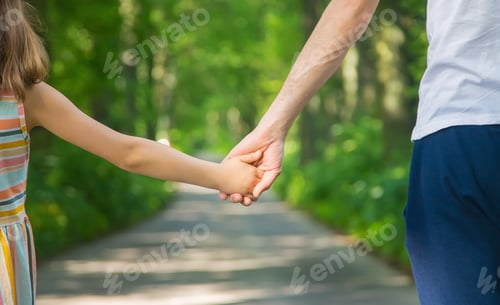 Preview: Father and child go holding hand. Selective focus.