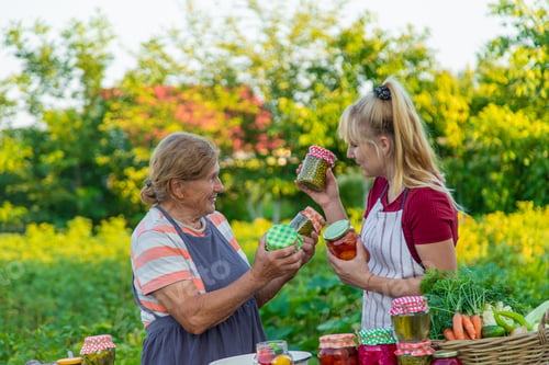 Preview: Women with jar preserved vegetables for the winter mother and daughter. Selective focus.
