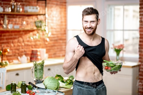 Preview: Sports man with healthy salad at home