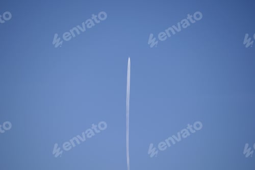 Preview: Distant passenger jet plane flying on high altitude on clear blue sky leaving white smoke