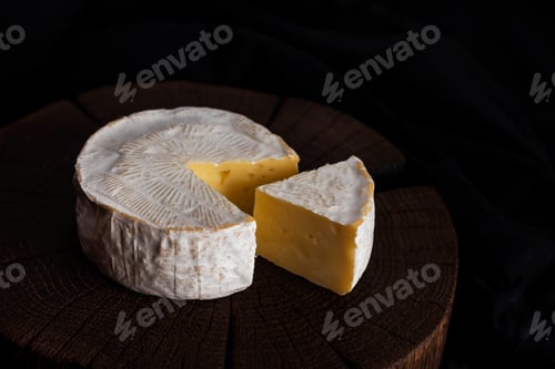 Preview: Camembert cheese on black wooden background, with copy space. Shallow depth of field