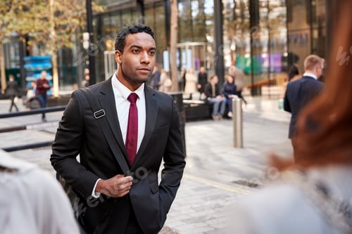 Visualização: Jovem empresário negro andando em uma rua da cidade, foco seletivo