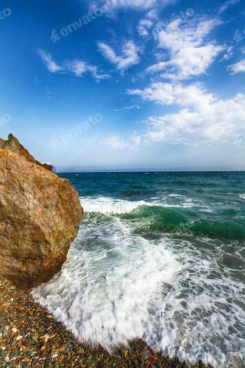 Preview: Sea waves crashing on the shore and flowing above seashore pebbl