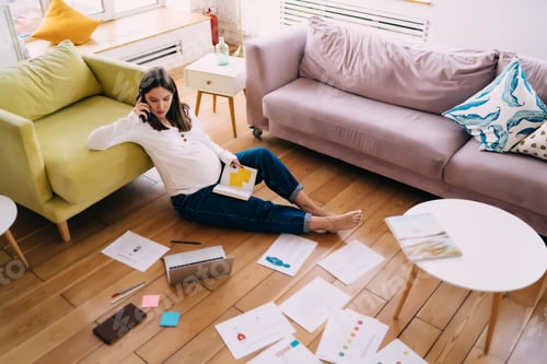 Preview: Focused expecting mother speaking on smartphone at home