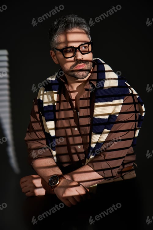 Preview: Handsome man showcases stylish elegance in a studio setting with dramatic lighting