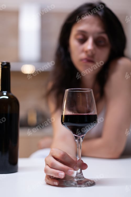 Preview: Close up of glass and bottle filled with wine for woman