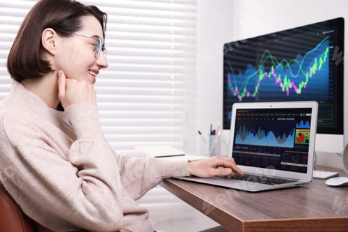 Preview: Stock exchange. Woman analysing financial market on laptop at wooden table indoors