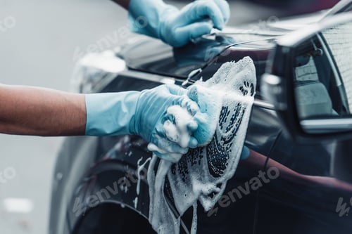 Preview: cropped view of car cleaner washing car with sponge and detergent