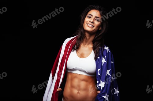 Preview: Happy young woman in sportswear holding American flag